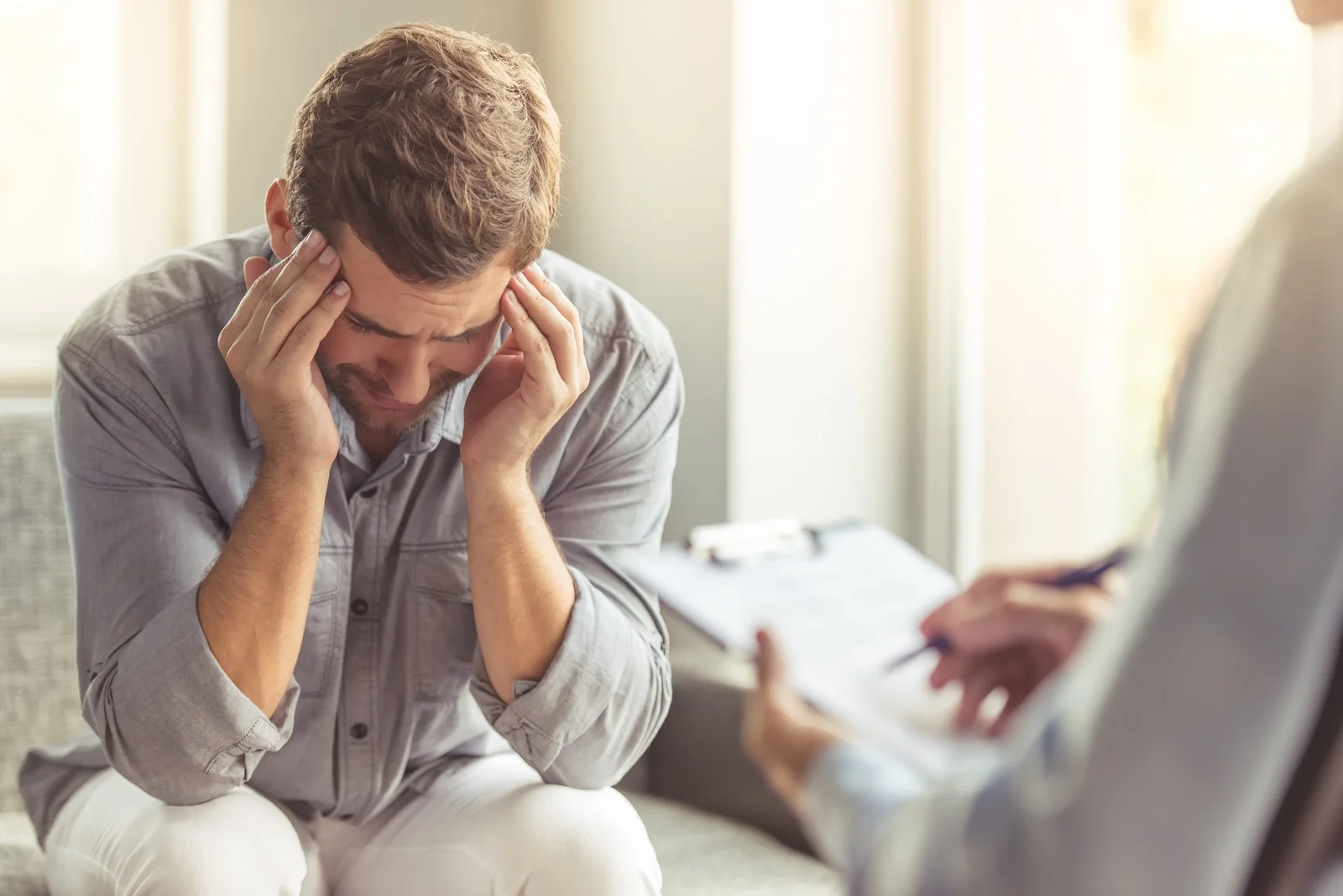 A man sitting with his head in his hands during a counseling session