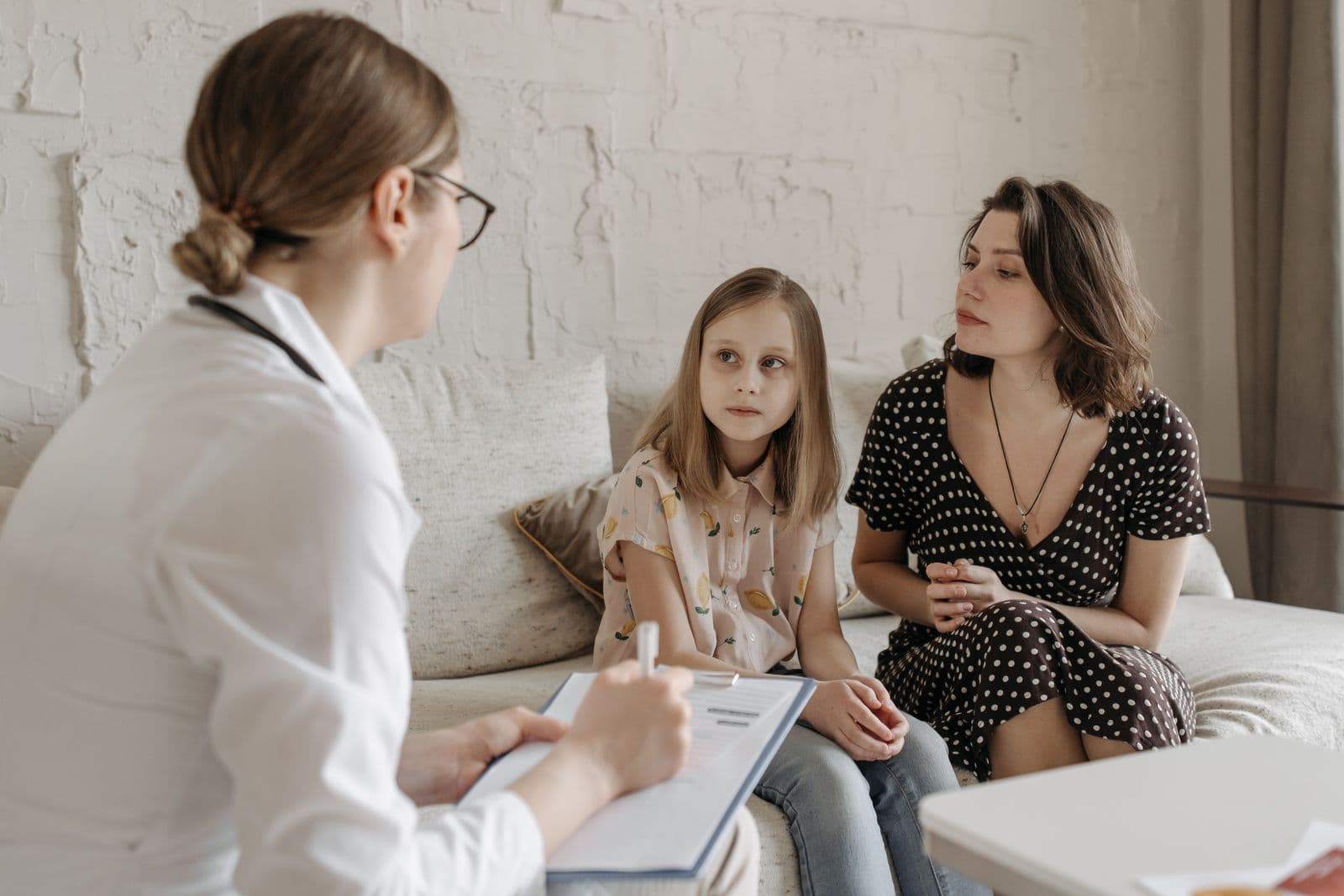 A doctor talking with a mother and her daughter